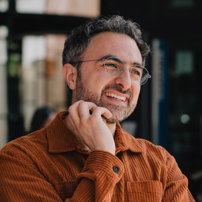 Mustafa_Suleyman CEO Inflection AI Scratching his beard in ponderous thought.